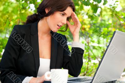 Portrait of a smiling young business woman using laptop at outdo