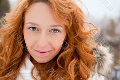 Portrait of young pretty woman in winter park 