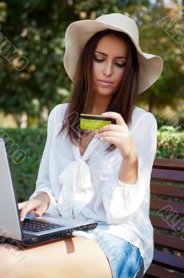 Young elegant woman wearing straw hat and white dress holding cr