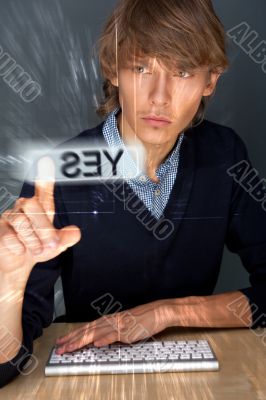 Young business man pressing a touchscreen button while working a
