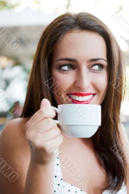 Closeup portrait of a pretty young female having a cup of coffee