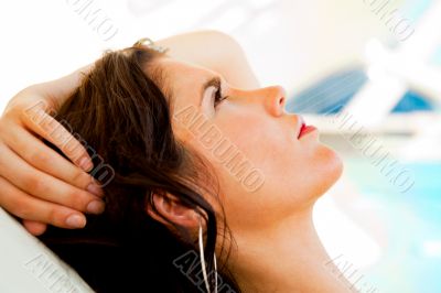 Pretty young woman resting at modern resort. Hotel building at t