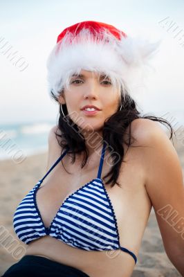Young beautiful woman wearing christmas hat showing heart shape 