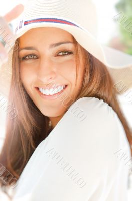 Portrait of pretty cheerful woman wearing white dress and straw 