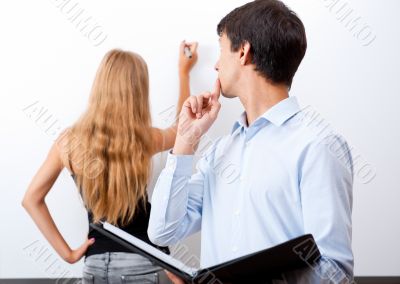 Closeup of adult teacher with student presenting her work on whi