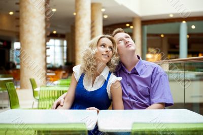Portrait of a happy young couple looking away while sitting near