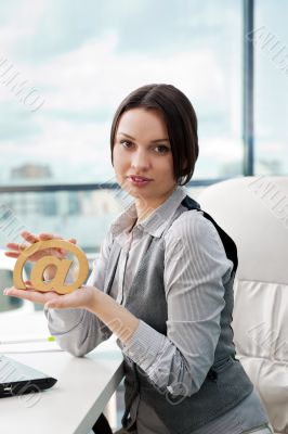 Portrait of a cheerful Business woman sitting on her desk holdin
