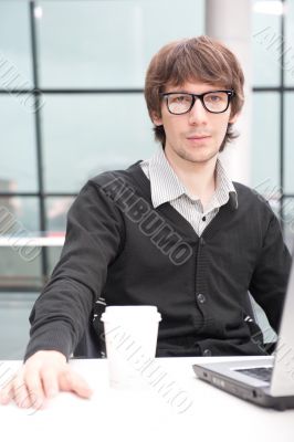 Friendly executive sitting in front of laptop