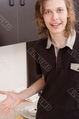 Happy young man after having a breakfast at home