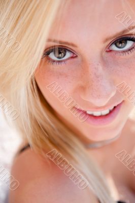 Portrait of pretty young woman standing outdoors near white wall