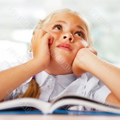 Portrait of a young girl in school at the desk.