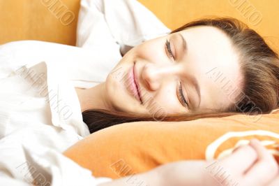 Closeup portrait of young pretty girl laying on her bed