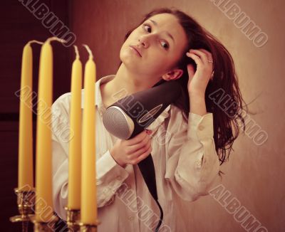 Beautiful woman drying her hair with hairdryer