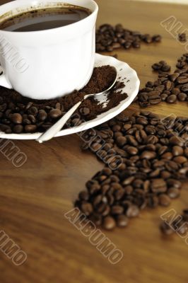 Dramatic photo of world map made of coffee beans. White cup with
