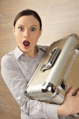 Portrait of a beautiful young businesswoman holding a suitcase a