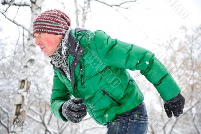 Closeup portrait of young man running in winter park