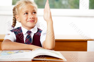 Image of smart child reading interesting book in classroom. Hori