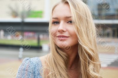 Closeup portrait of a beautiful woman in the city at summer time