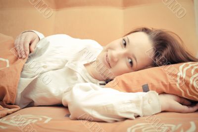 Closeup portrait of young pretty girl laying on her bed