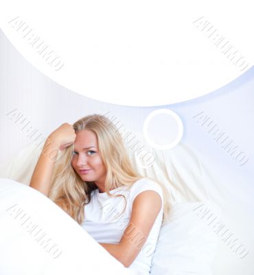 Young blond woman enjoying a sunny morning in bed