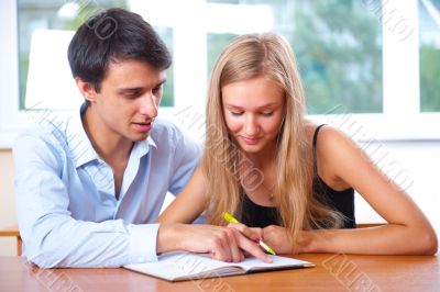 Portrait of teacher helping young student with her studies in co