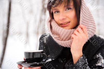 Portrait of young beautiful woman standing alone in winter park 
