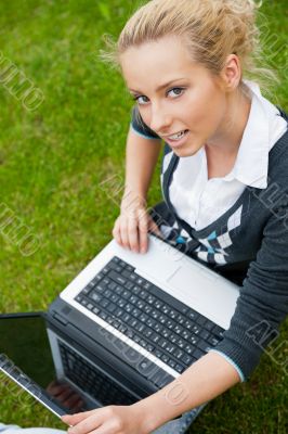 Beautiful young woman using laptop at outdoor