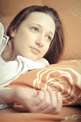 Closeup portrait of young pretty girl laying on her bed