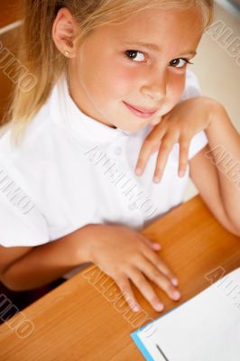 Image of smart child reading interesting book in classroom