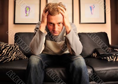 Closeup portrait of young man sitting on sofa 