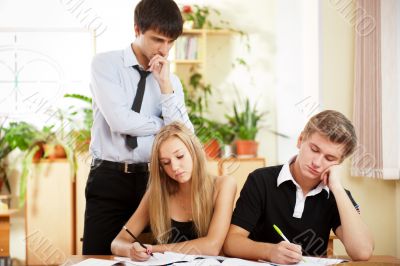 Teacher helping students in school classroom. Horizontally frame