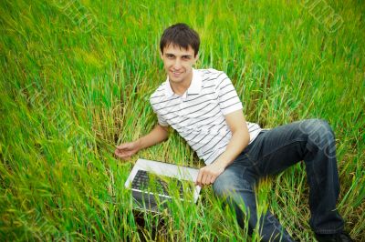 A smiling man with laptop outdoor