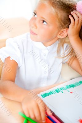 Little girl looking for a drawing concept wile painting picture 