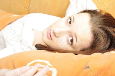 Closeup portrait of young pretty girl laying on her bed