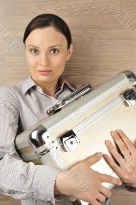 Portrait of a beautiful young businesswoman holding a suitcase.