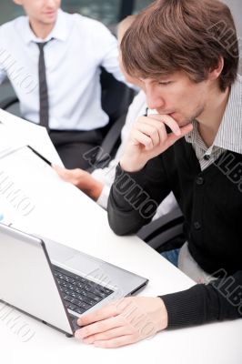 Friendly executive sitting in front of laptop