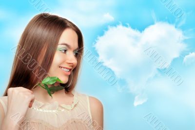 Portrait of young pretty woman holding green leaves