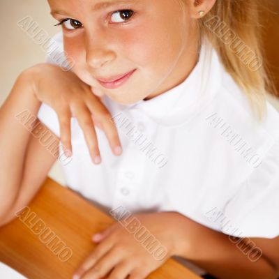 Image of smart child reading interesting book in classroom