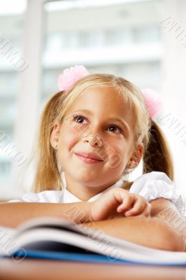 Portrait of a young girl in school at the desk.