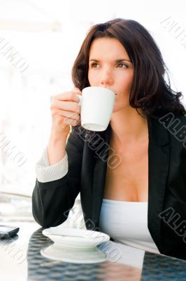 Closeup portrait of cute young business woman smiling while drin