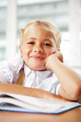 Portrait of a young girl in school at the desk.