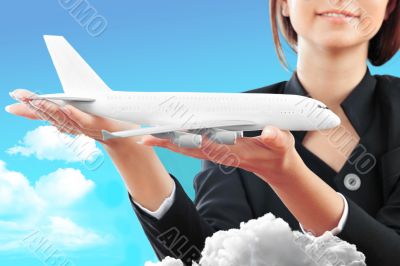 Portrait of young happy woman stewardess holding jet aircraft in