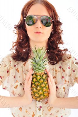 Closeup portrait of woman in sunglasses holding pineapple in her