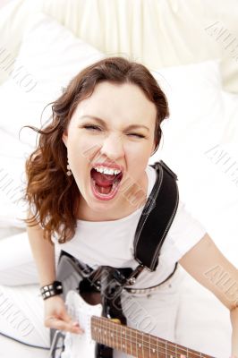 Portrait of beautiful young and attractive womanplaying her guit