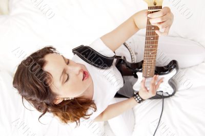 Portrait of beautiful young and attractive womanplaying her guit