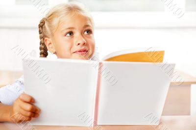 Image of smart child reading interesting book in classroom. Hori