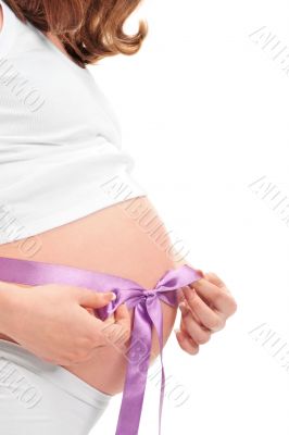 Image of pregnant woman touching her belly with hands