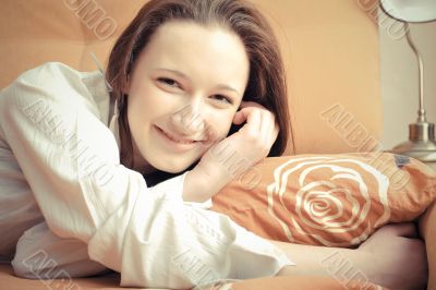 Closeup portrait of young pretty girl laying on her bed