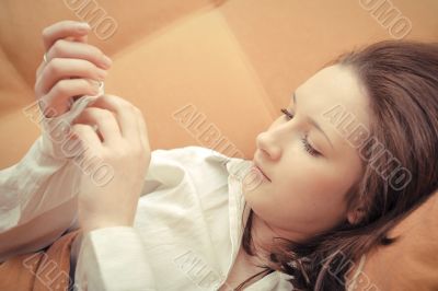 Closeup portrait of young pretty girl laying on her bed