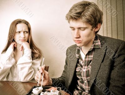 Attractive young couple eating sushi